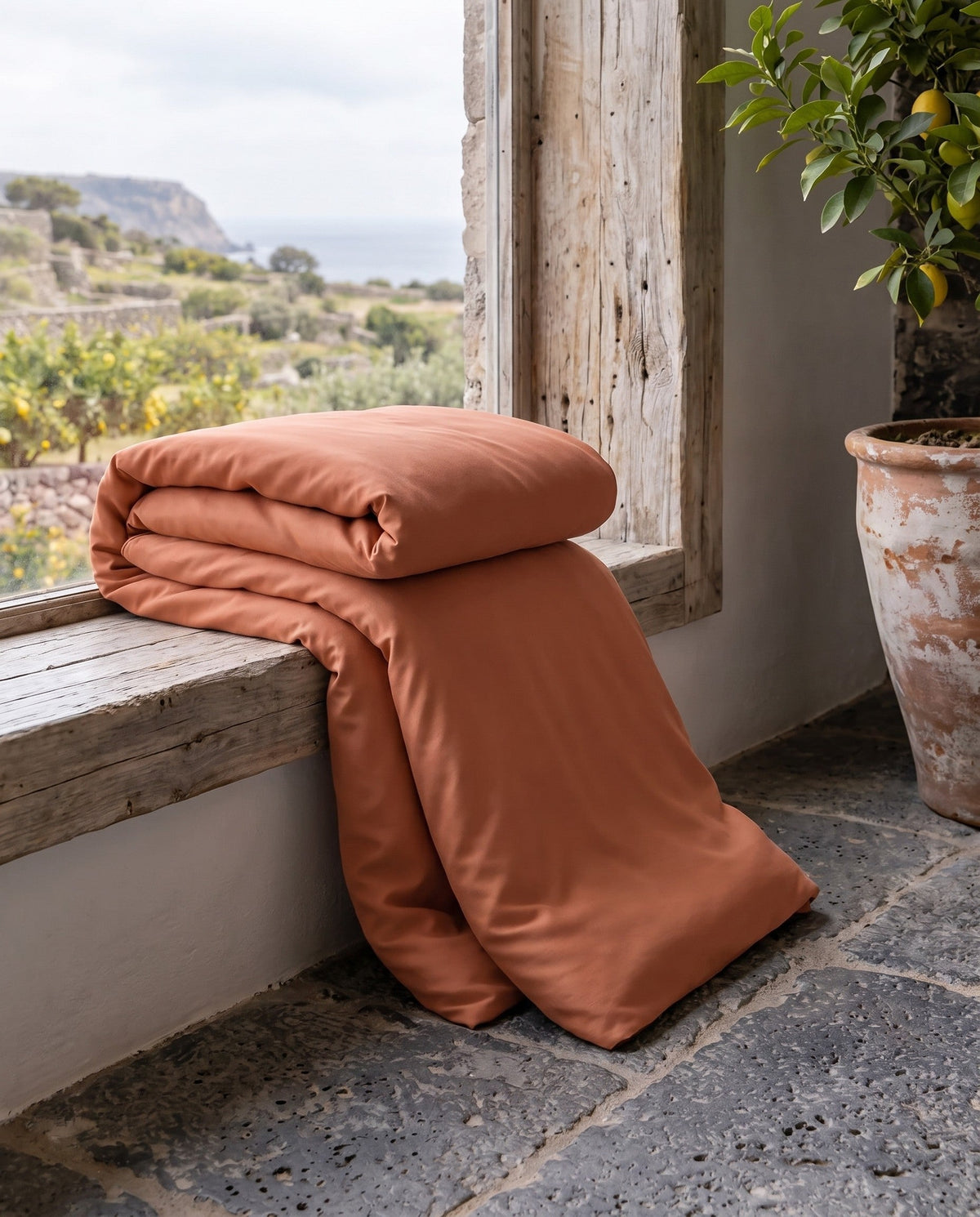 Copripiumino in viscosa di bambù piegato sul davanzale | Terracotta
